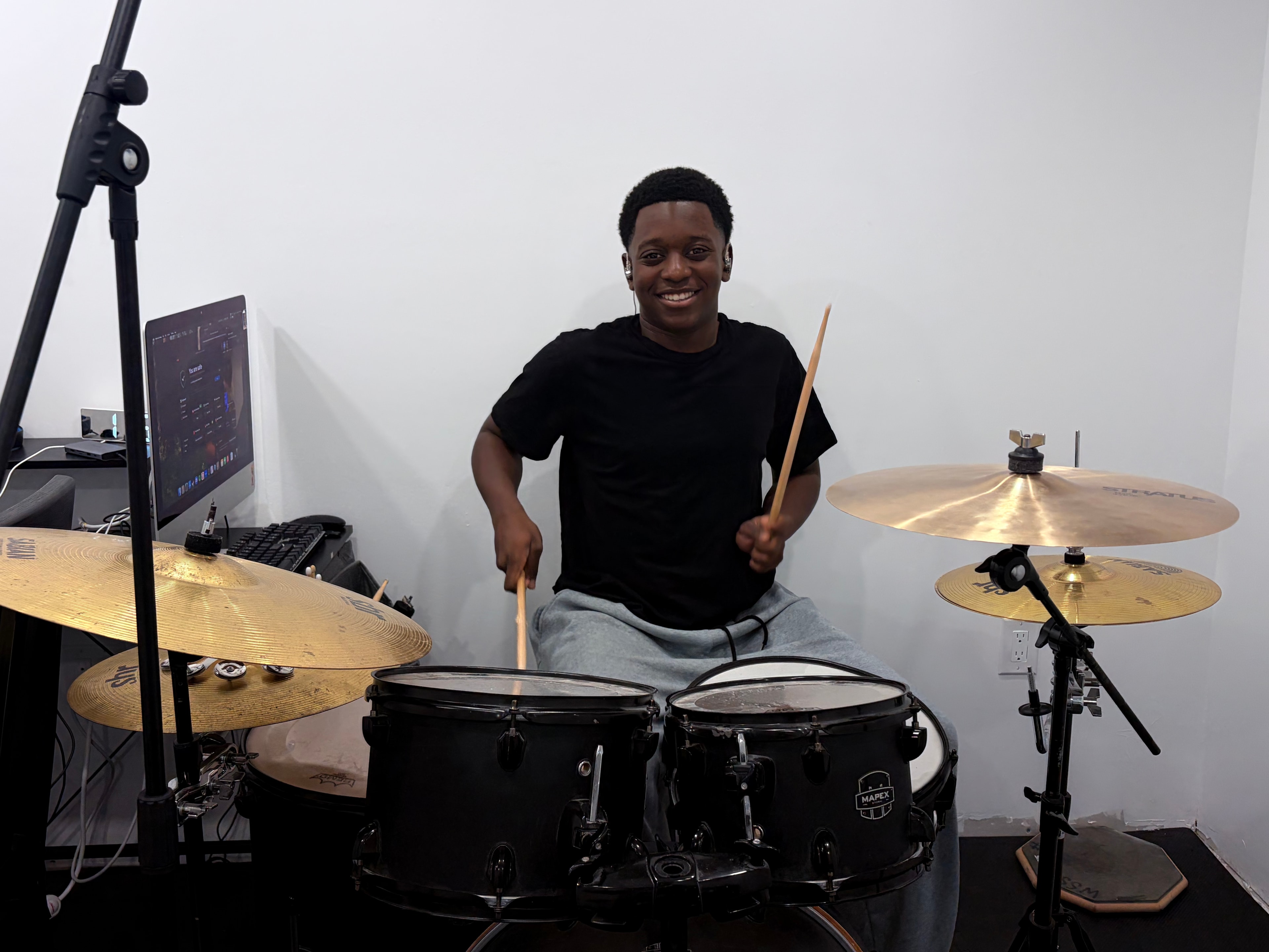 Caleb playing drums in his studio